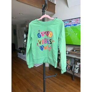 Lola + The Boys green sweatshirt featuring a colorful "Good Vibes Only" 8